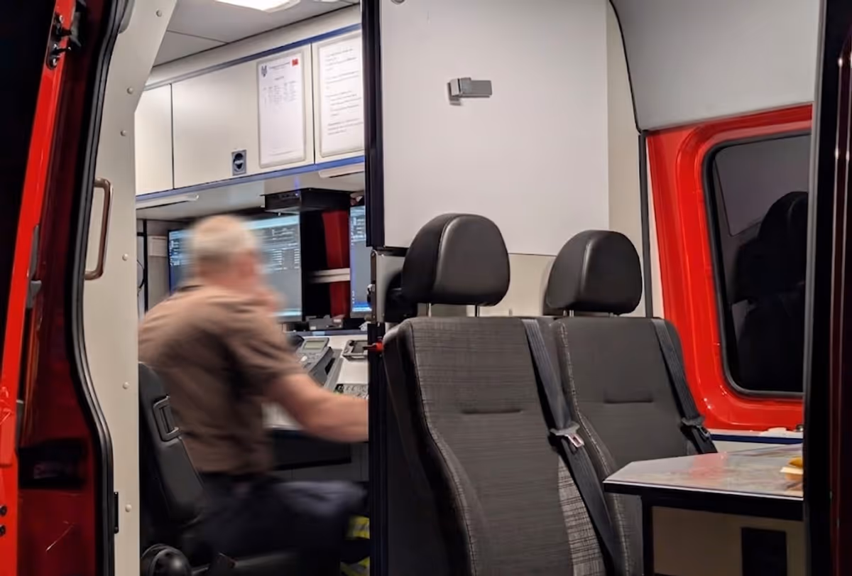 Arbeitsplatz im ELW1 mit Funk, Bildschirmen und Dokumentationsunterlagen